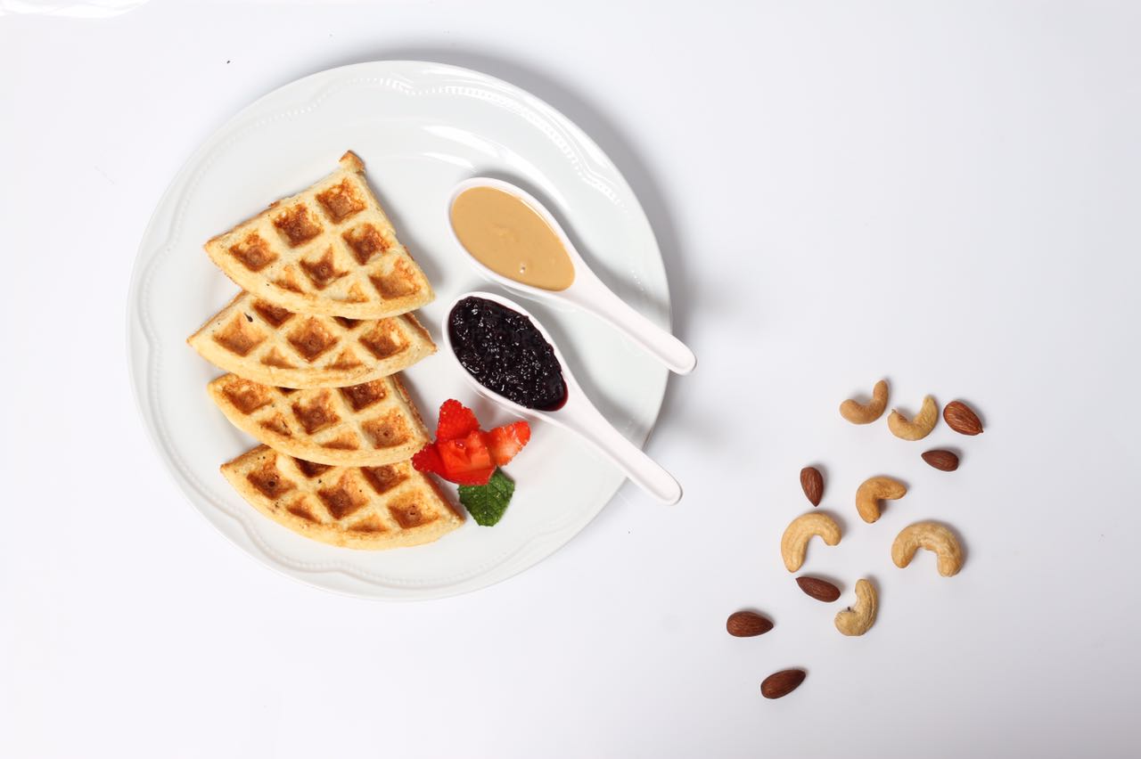 waffle de whey (proteína) que leva farinha de coco, não contém açúcar e acompanha pasta de amendoim e geleia de mirtilo. Foto: divulgação